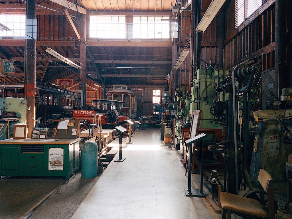 Inside the Trolley Barn at History Park San Jose with restored streetcars and antique vehicles