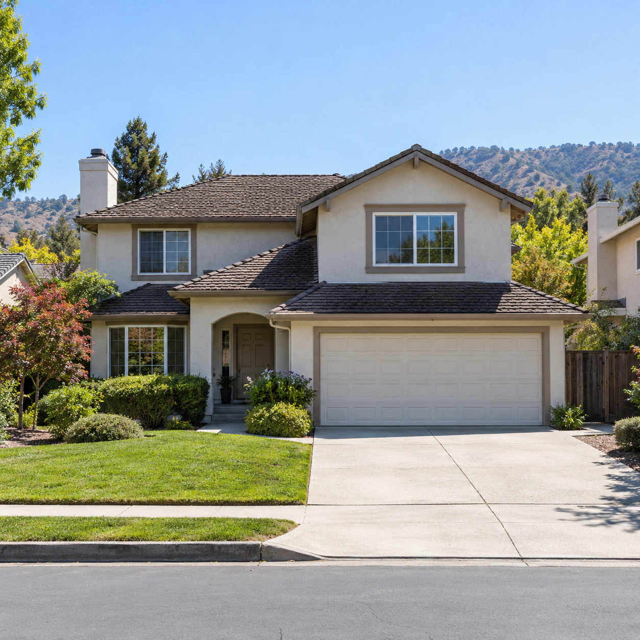 Two-story Silicon Valley family home with a front lawn and hills behind it