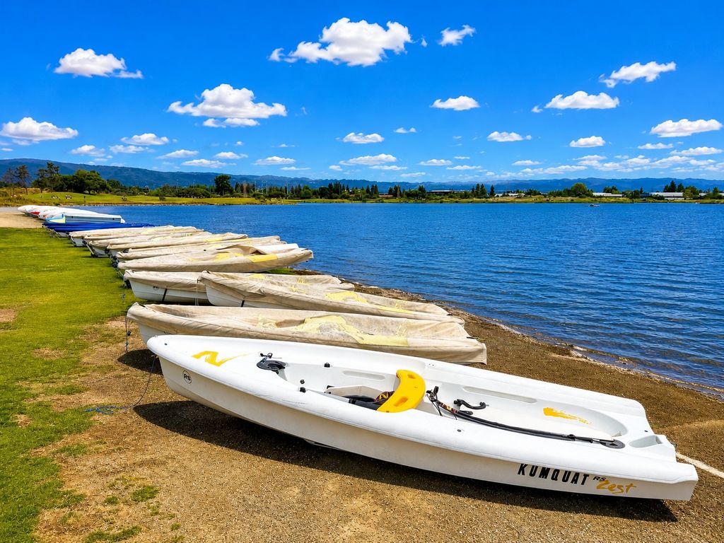 Row of covered RS Zest rental sailboats beached on the shore of Shoreline Lake in Mountain View on a sunny day