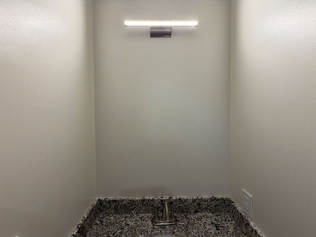Granite bathroom vanity with LED light bar in a resident suite at Villa Toscana Memory Care