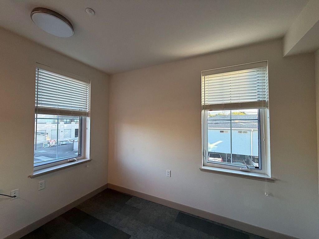 Unfurnished corner resident suite with two windows at Villa Toscana Memory Care