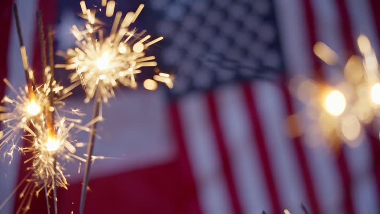 Sparklers with an American flag background.