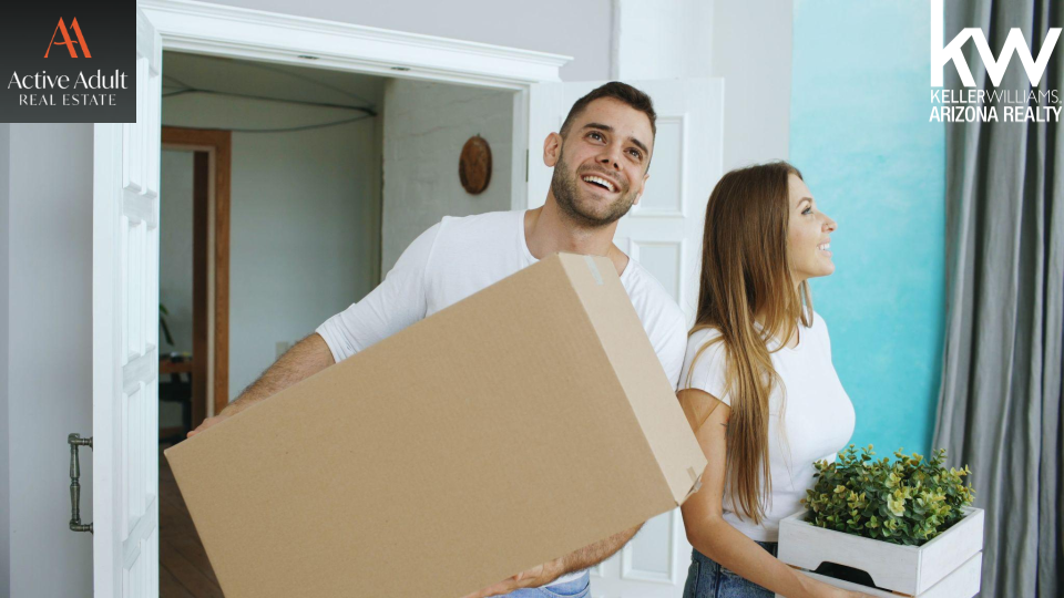 Marta Baxter and Rod Horn Active Adult Real Estate Blog Post Image, Couple under 55 carrying moving boxes and planters, both wearing white shirts, learning Can Someone Under 55 buy into 55+ Community