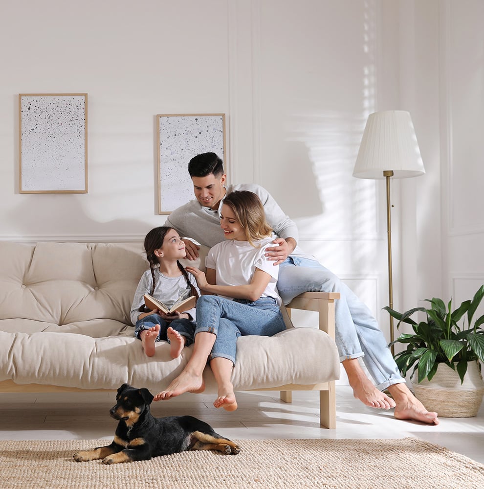 Happy,Family,On,Sofa,And,Puppy,In,Living,Room