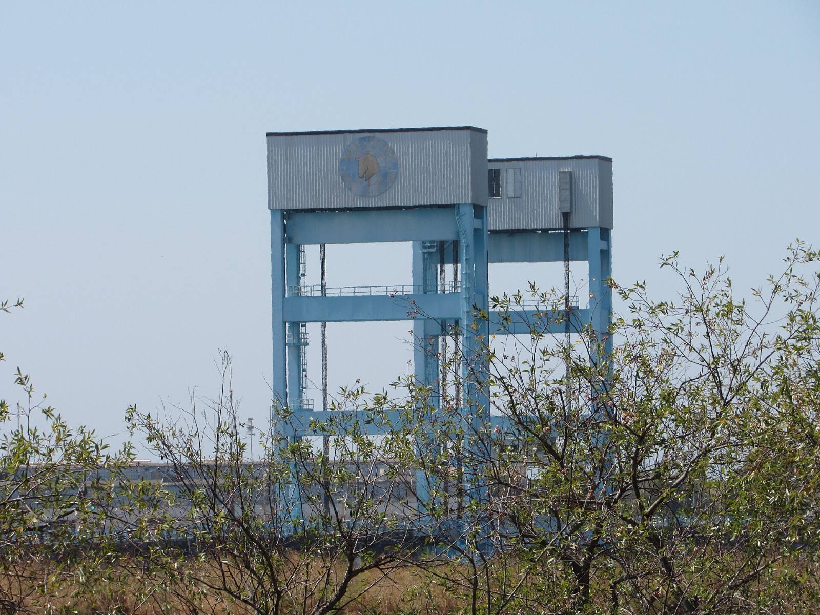 The Mare Island Causeway lift bridge towers seen over brush, Vallejo, California, August 2022