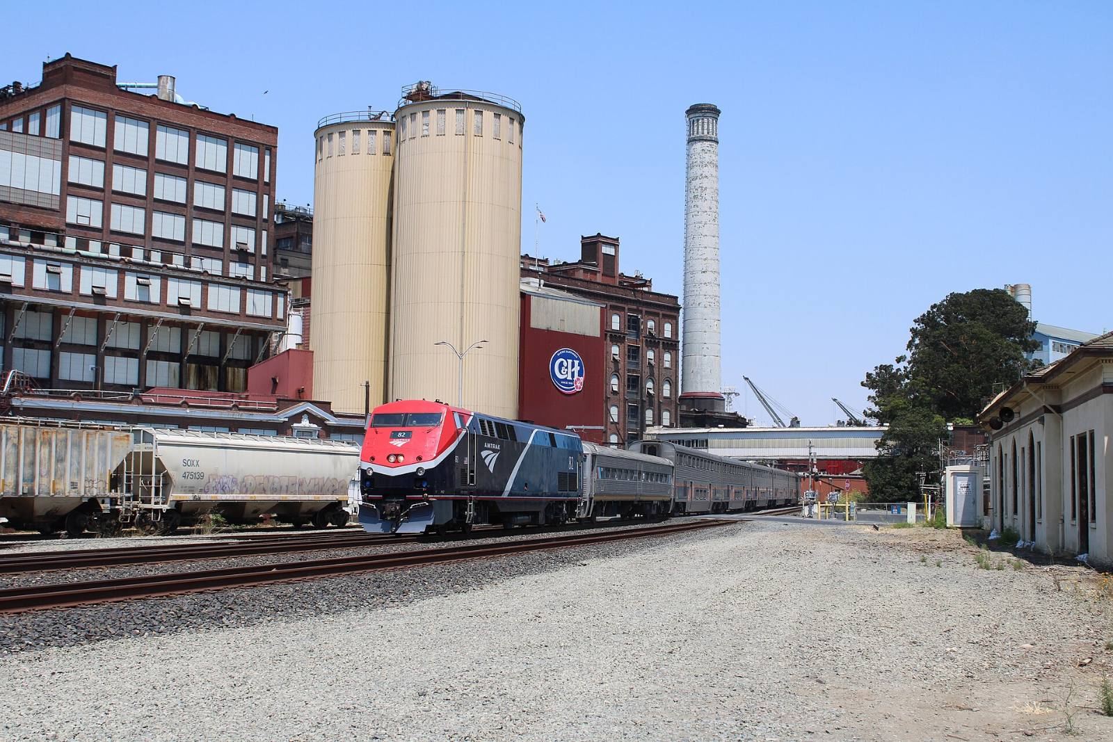 A San Joaquins passenger train passing the C&H sugar refinery buildings in Crockett, California, July 2025