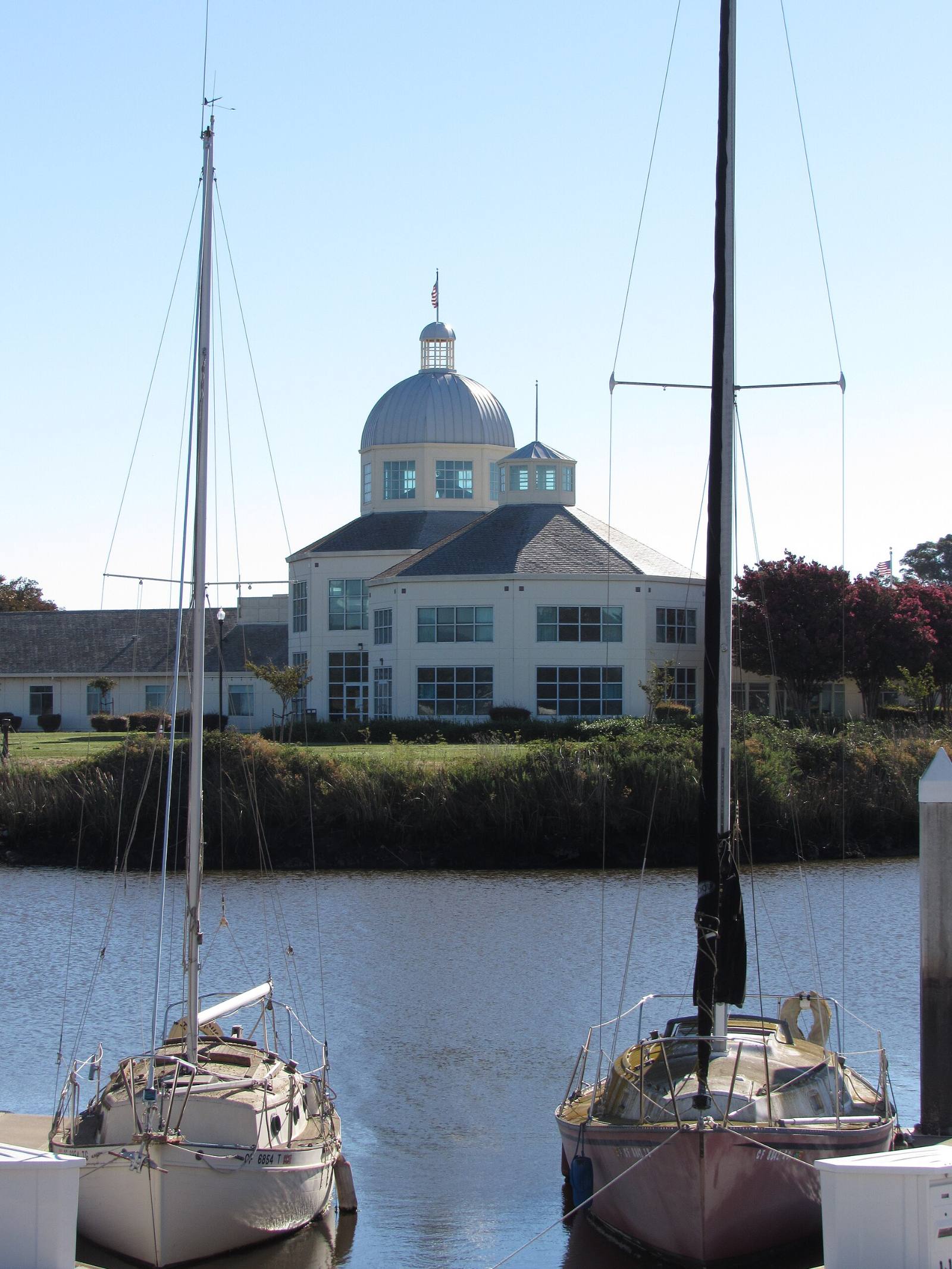 Suisun City Hall seen across Suisun Slough between two boats in the harbor, Suisun City, California, August 2022