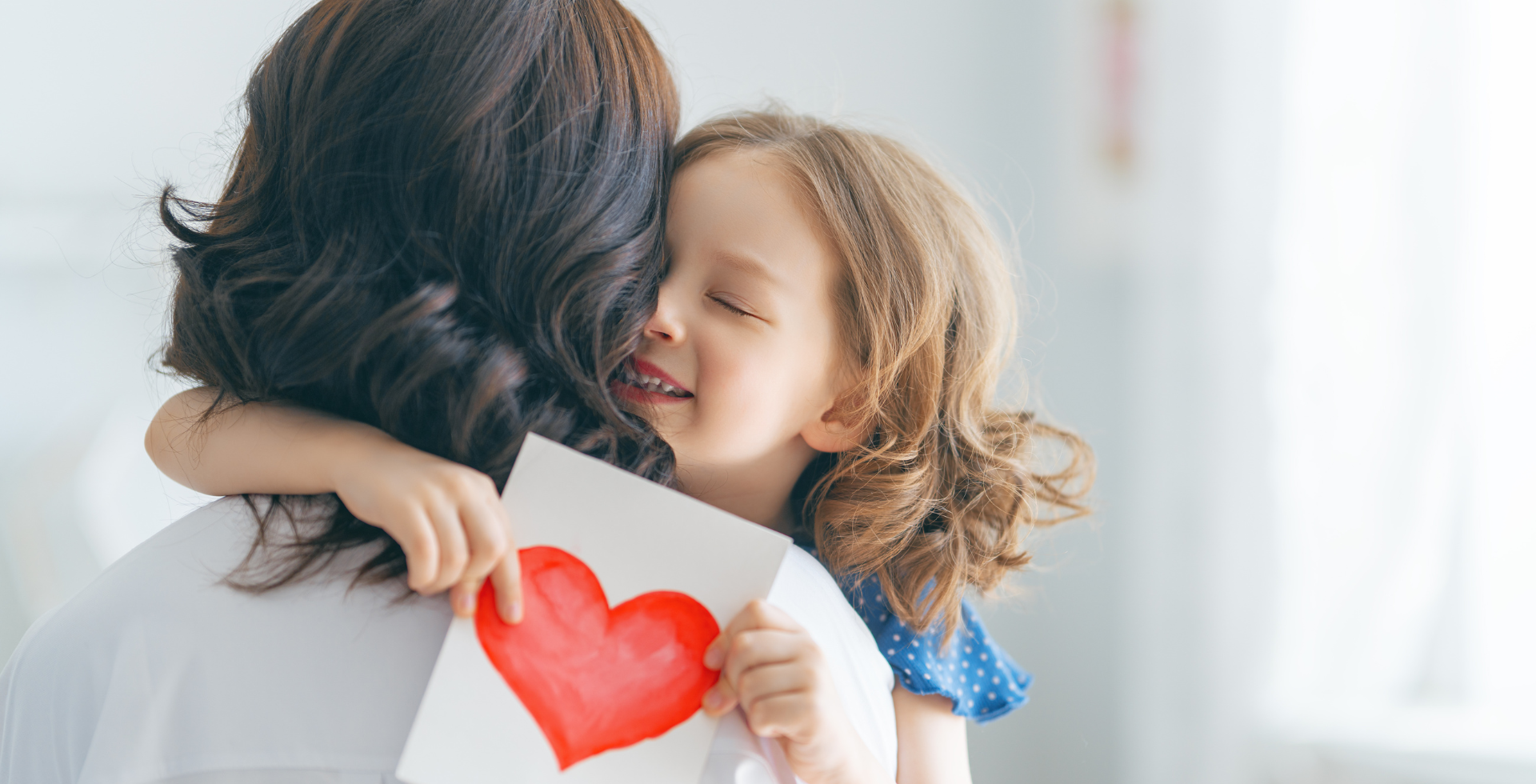 Mother and Daughter Hugging on Mother’s Day with Flowers
