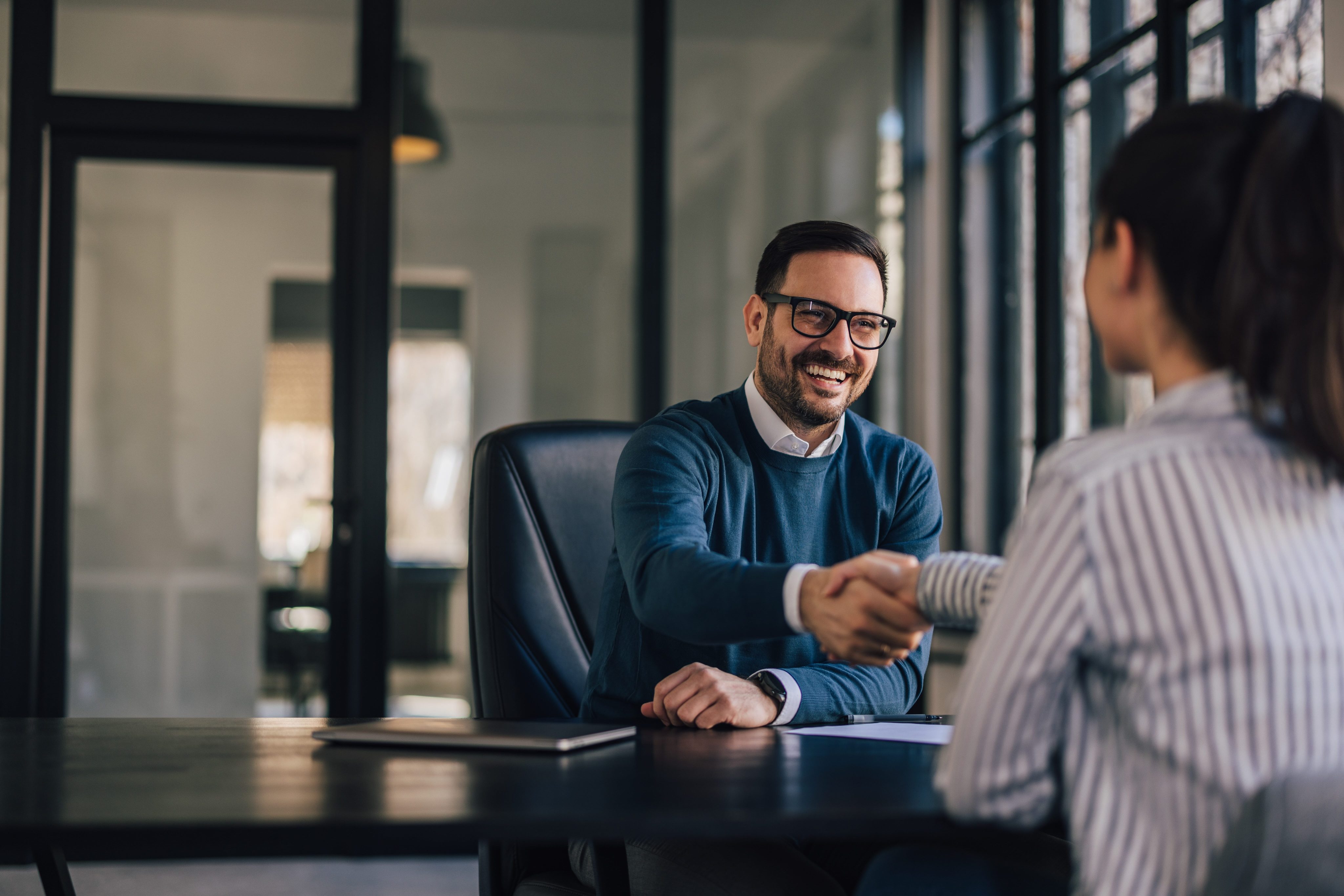 Business people, smiling faces, shaking hands.
