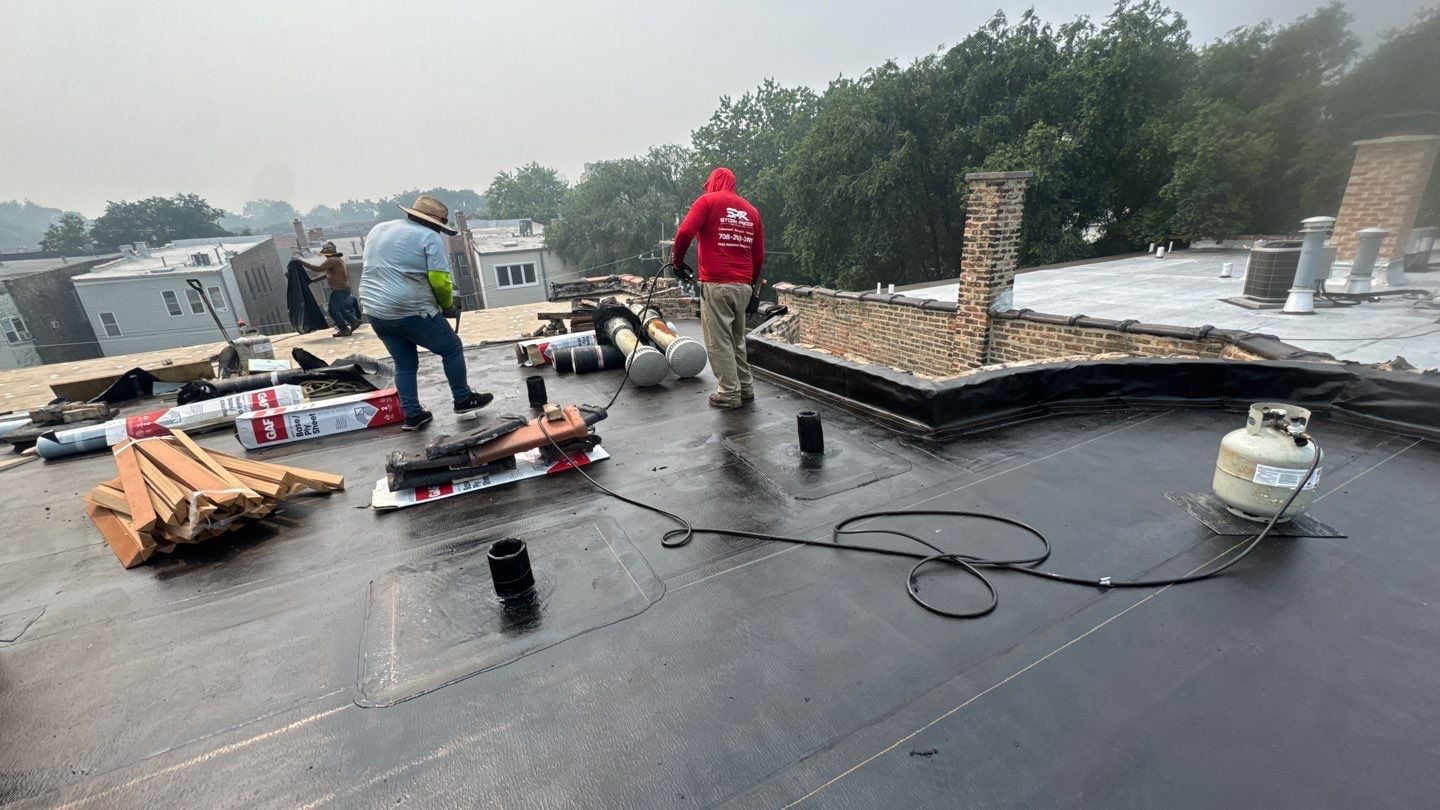 Roofing crew installing the new flat roof system