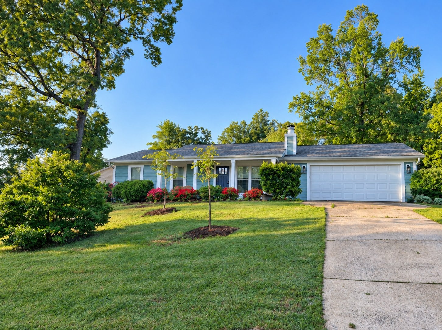 Blue ranch-style home with a white garage door and landscaped front yard at 4900 Cricklewood Lane in Vernedale Farms, East Charlotte