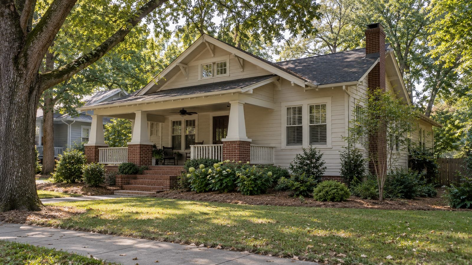 Craftsman bungalow with a deep front porch on a tree-lined Charlotte street