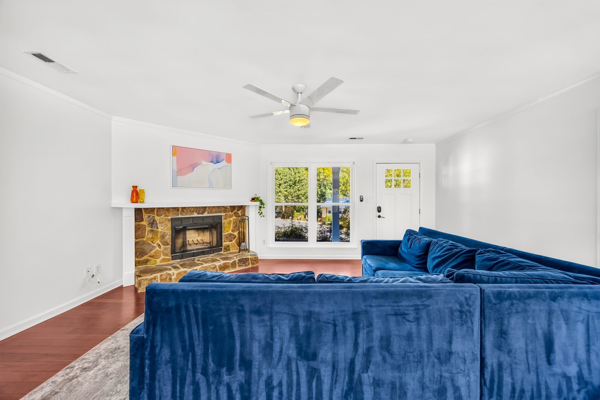 Family room with stone fireplace and wood floors at 4900 Cricklewood Lane