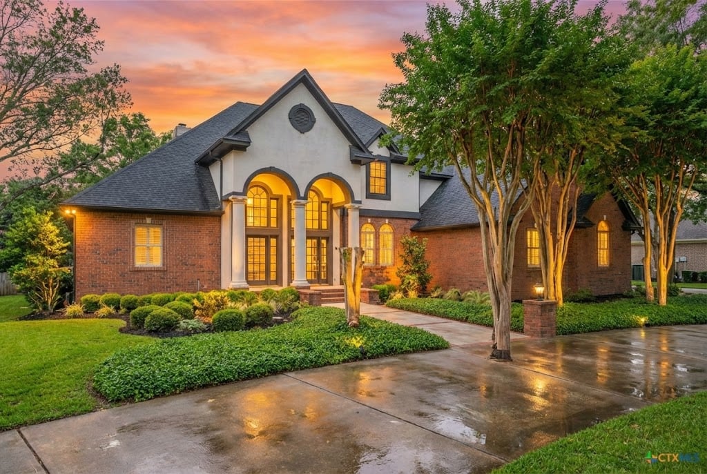 River Place home in Belton TX - brick estate with mature landscaping at twilight