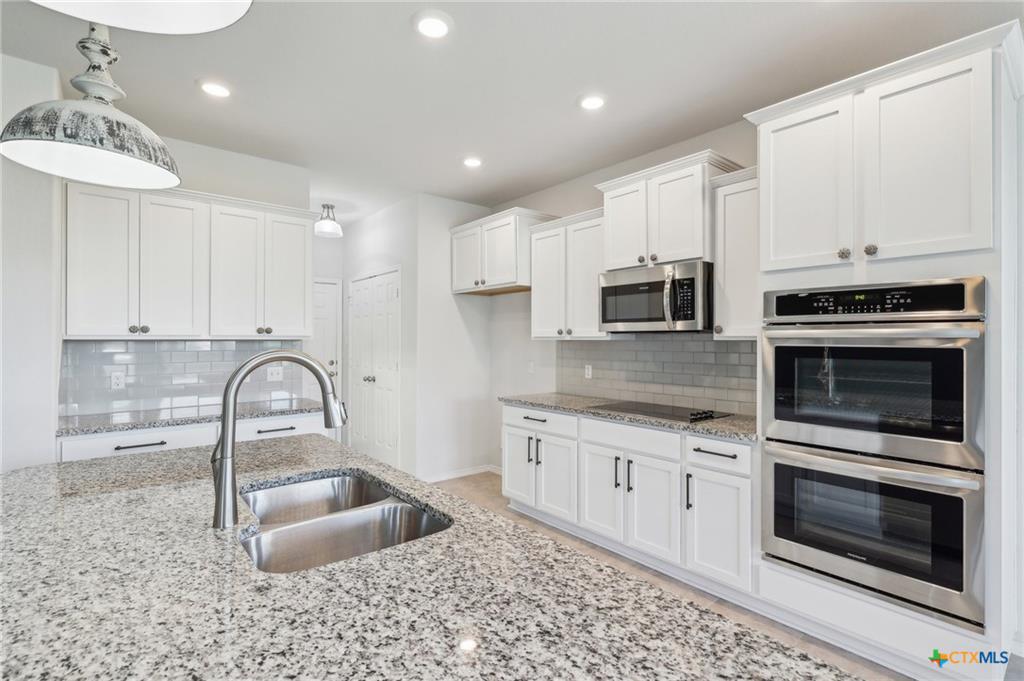 White kitchen cabinets and island in newer D.R. Horton Alta Vista home