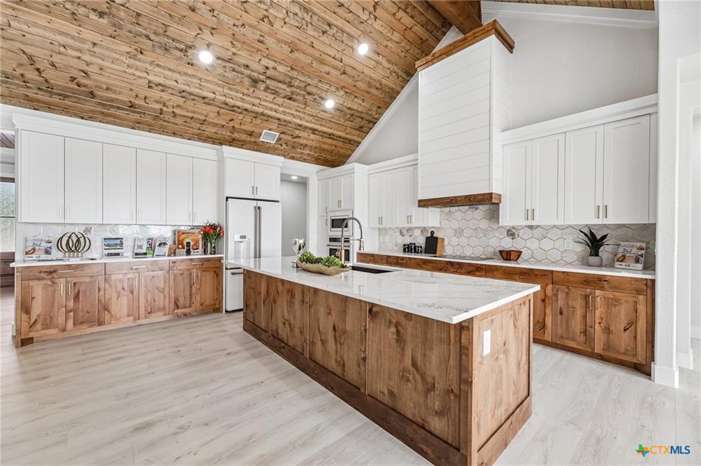 Custom Mill Creek kitchen with stone hood and large island