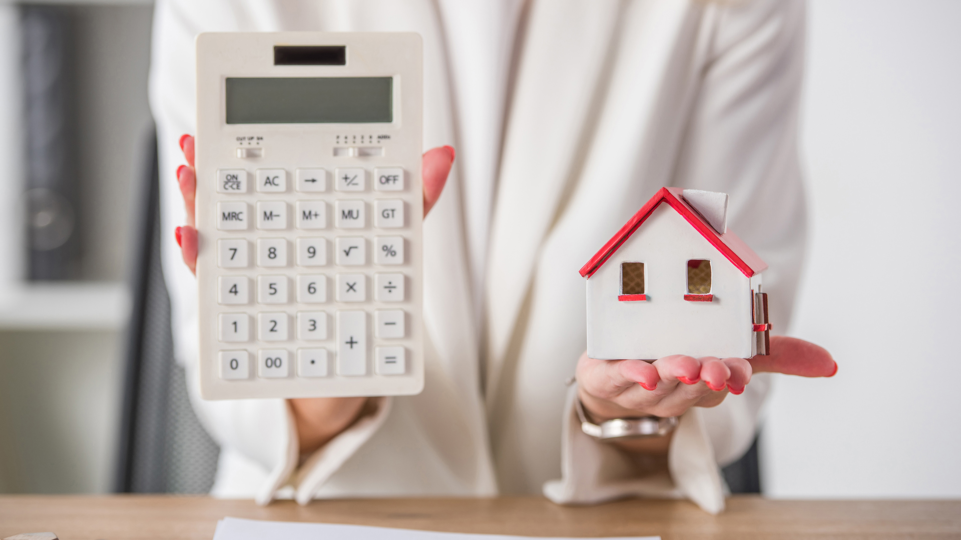 partial view of businesswoman showing house model and calculator