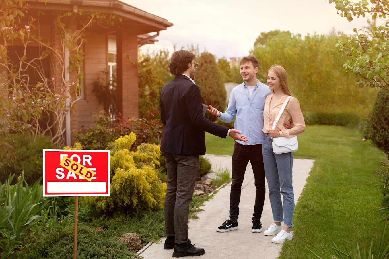 Real estate broker and new home owners in front of their property outside
