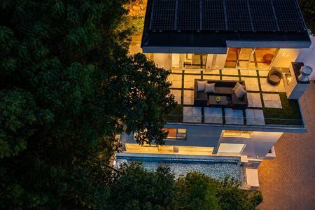 52-31 Casta Modern house at dusk surrounded by trees