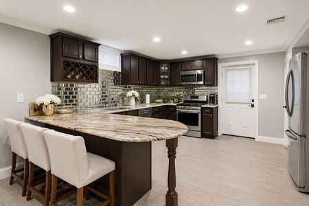 42. 5 Gates Pl. Modern kitchen with marble island and flowers