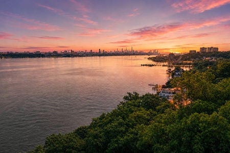 48. 35 Shore Serene sunset over riverside cityscape