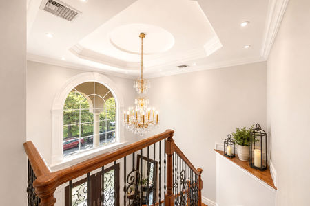 60. 335 Riverdale Elegant foyer with wooden staircase and chandelier