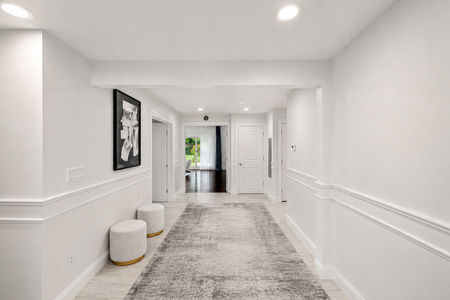10. 108 Briarwood Minimalist Hallway with Gold Ottomans and Rug