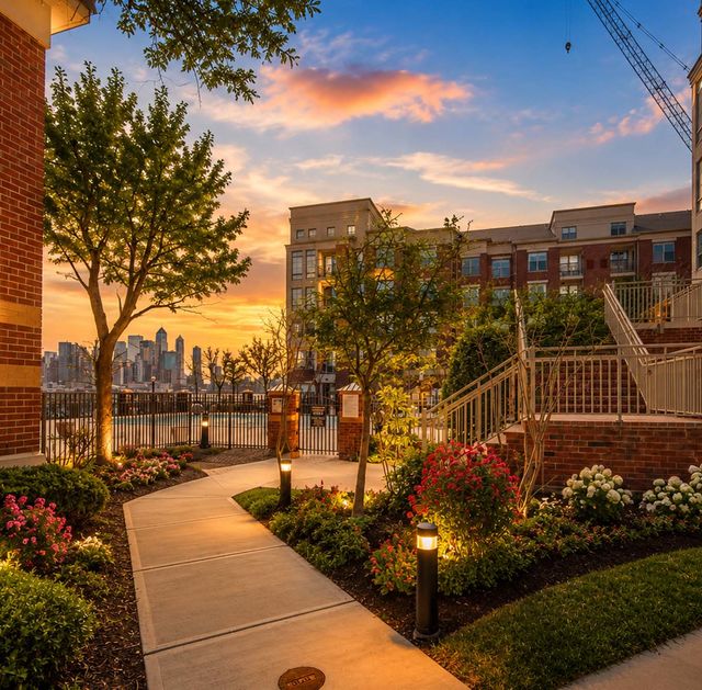 26 Ave Port Imperial Serene courtyard at sunset with skyline