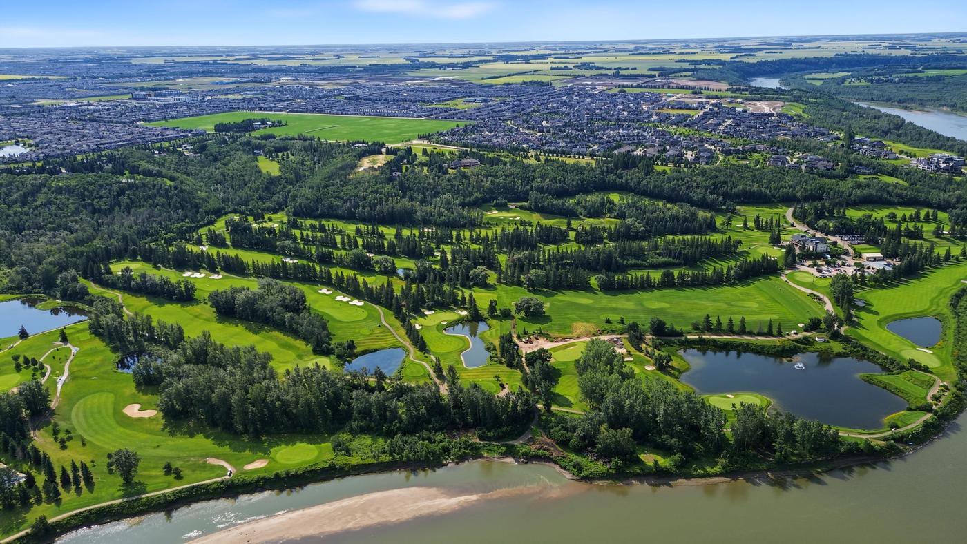 Wide aerial of the valley showing ponds, fairways and treed slopes running down to the river.
