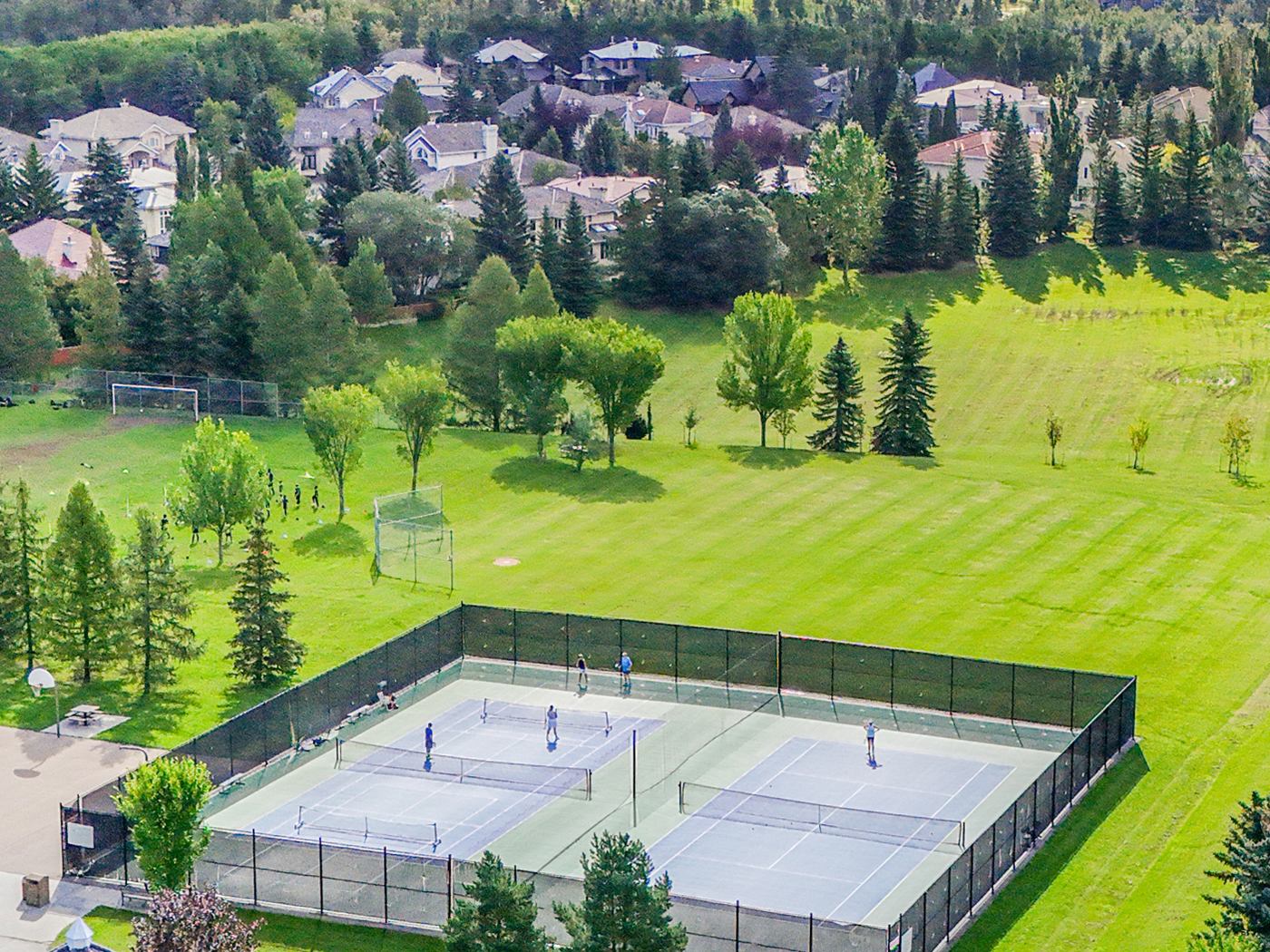 Aerial view of the community tennis and pickleball courts in use, with the houses beyond.