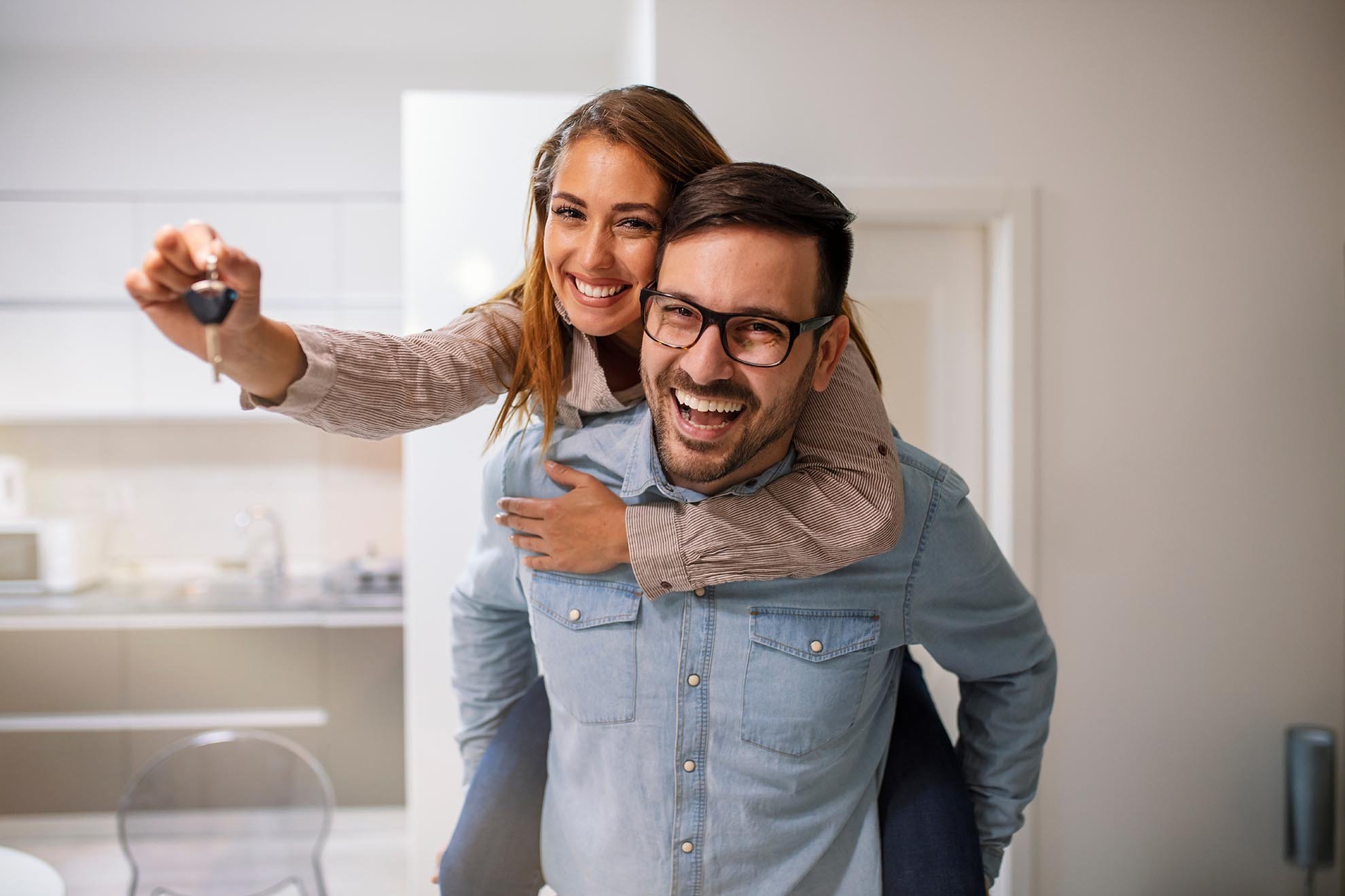 Couple showing keys to new home. Young couple holding up new hou
