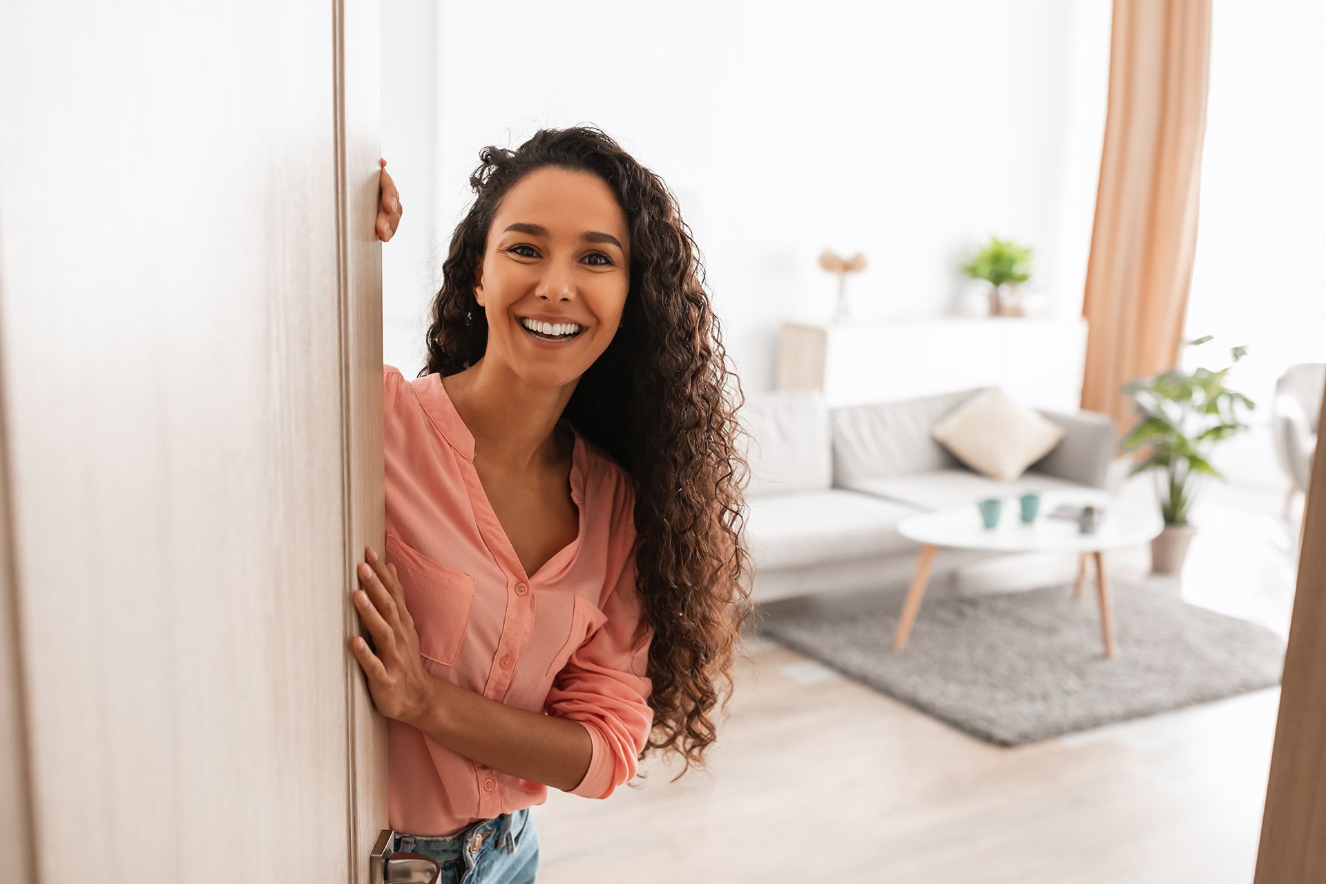 Welcome.,Portrait,Of,Cheerful,Woman,Standing,In,Doorway,Of,Modern