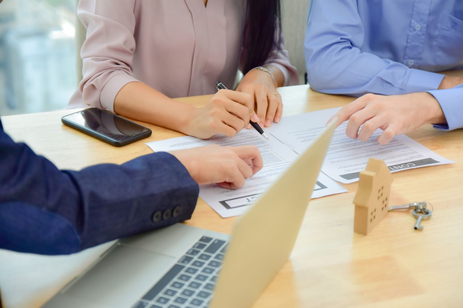 People signing papers at table