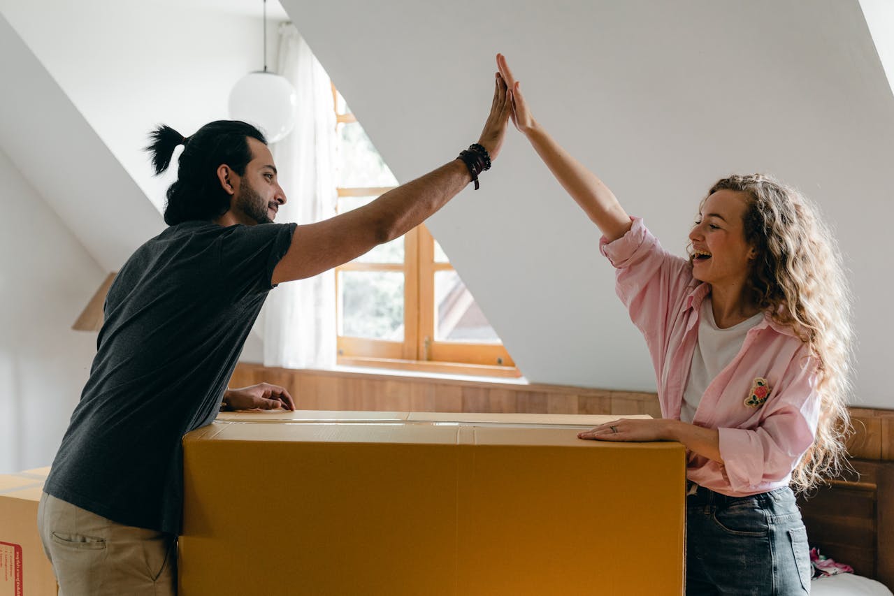 couple high fiving unpacking in new home