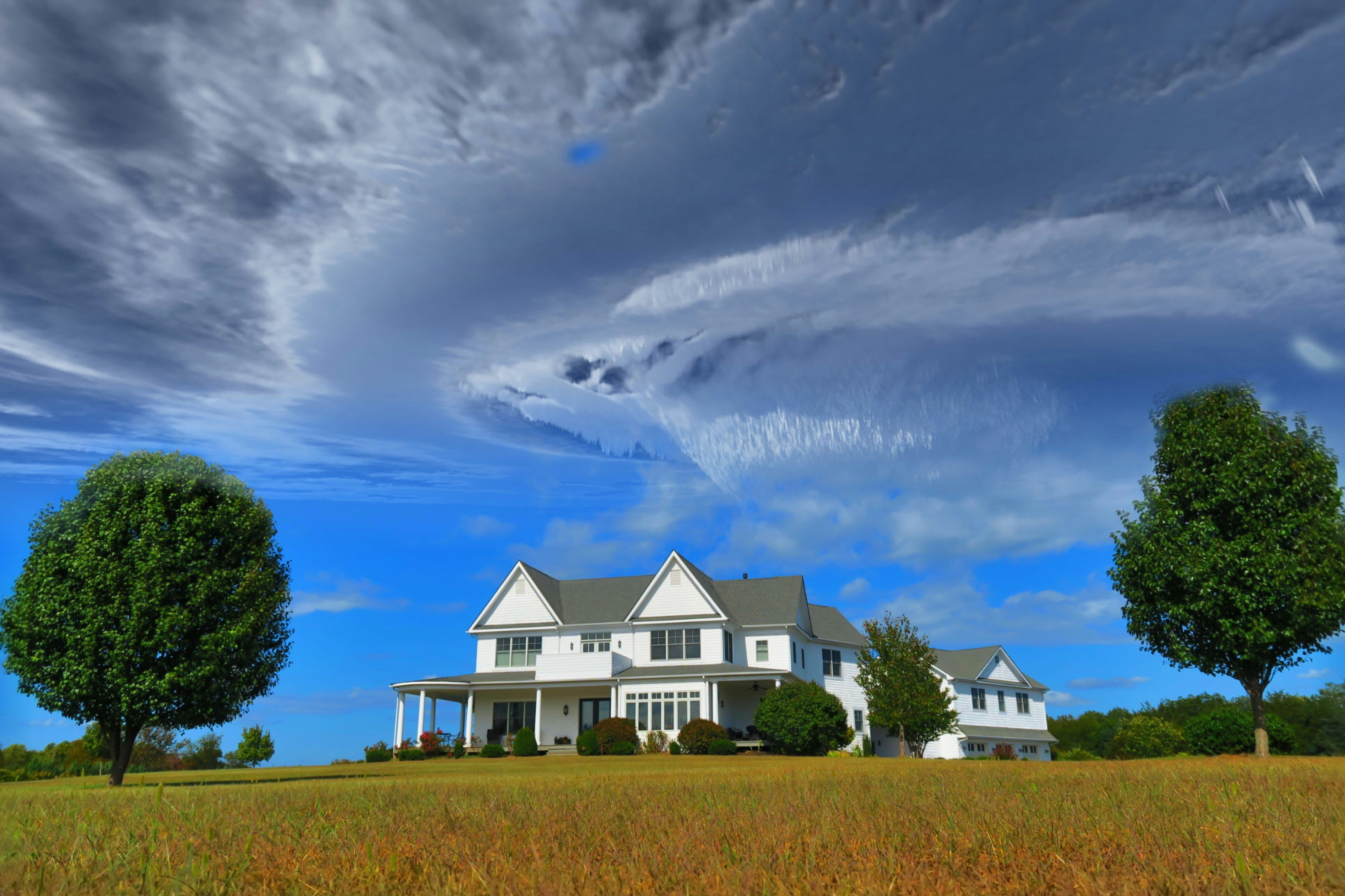 House with swirling clouds above