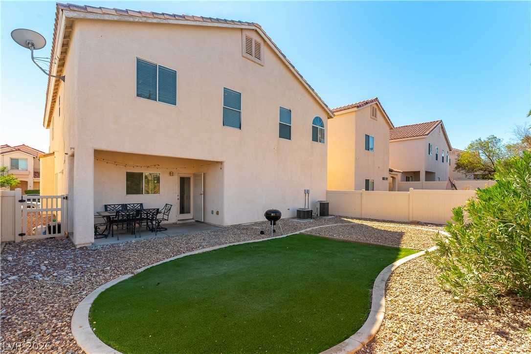 Backyard with synthetic turf and covered patio at 9010 Mossy Hollow Avenue