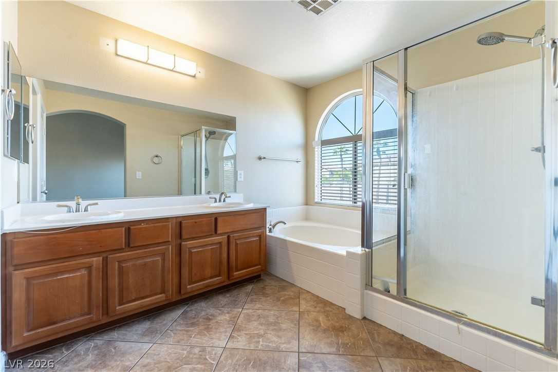 Bathroom with soaking tub and walk-in shower at 9010 Mossy Hollow Avenue