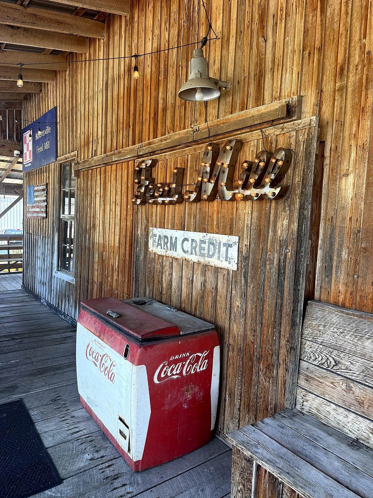 Feed Mill sign, Farm Credit sign and vintage cooler on the porch of the Nolensville Feed Mill