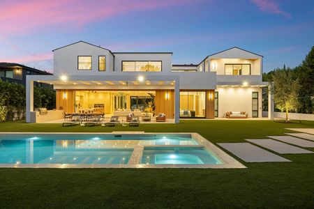 Modern luxury home with a pool and patio at sunset, featuring sleek architecture and outdoor living space