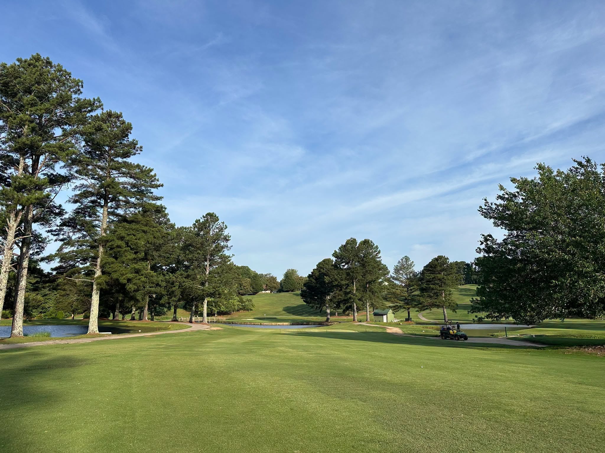 View of the golf course at Paris Mountain Country Club in Greenville, SC, featuring rolling fairways, mature trees, and water hazards.