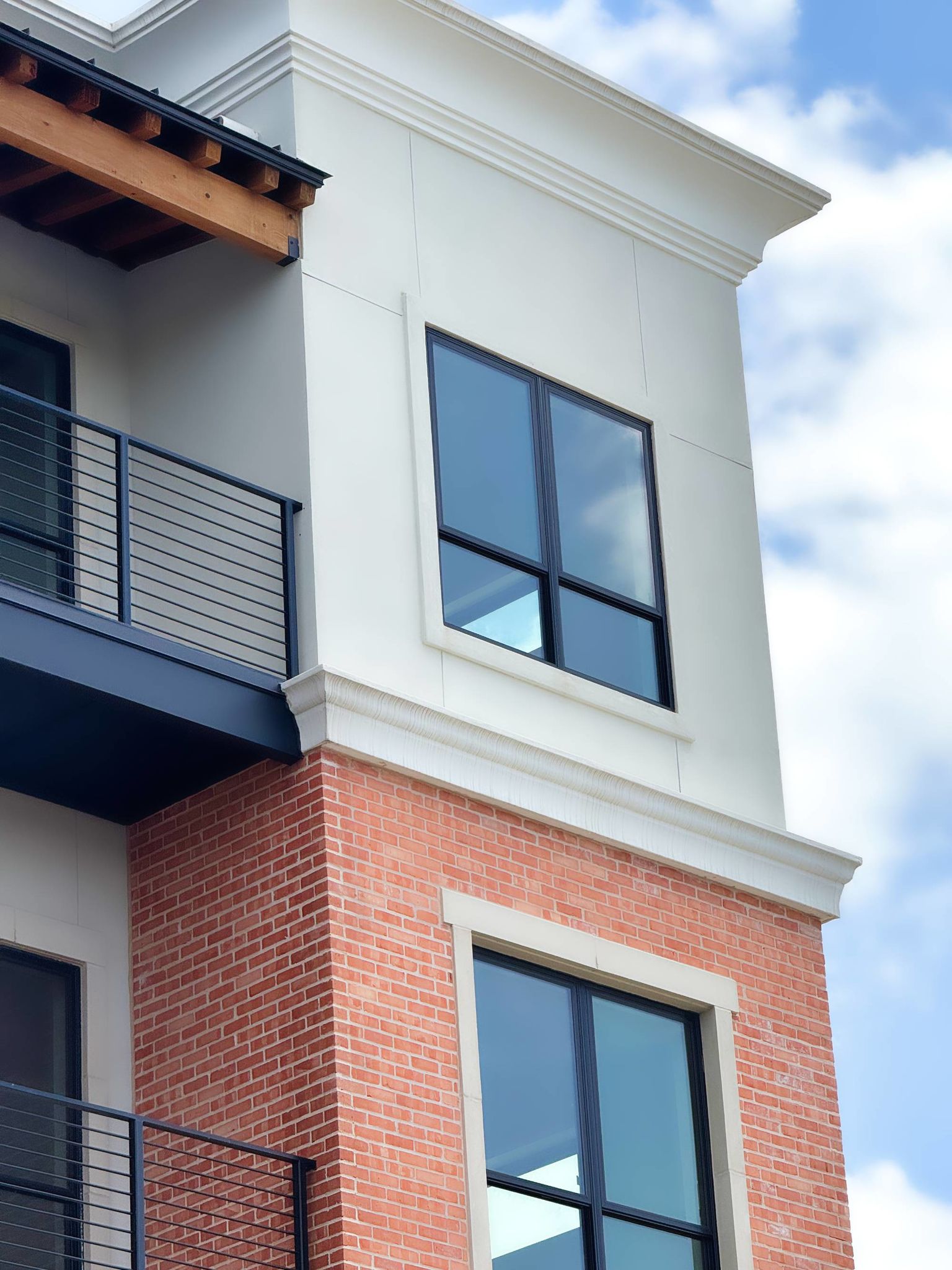 South Hausman Condos exterior featuring D'Hanis brick, cast stone, and smooth stucco with Pella windows