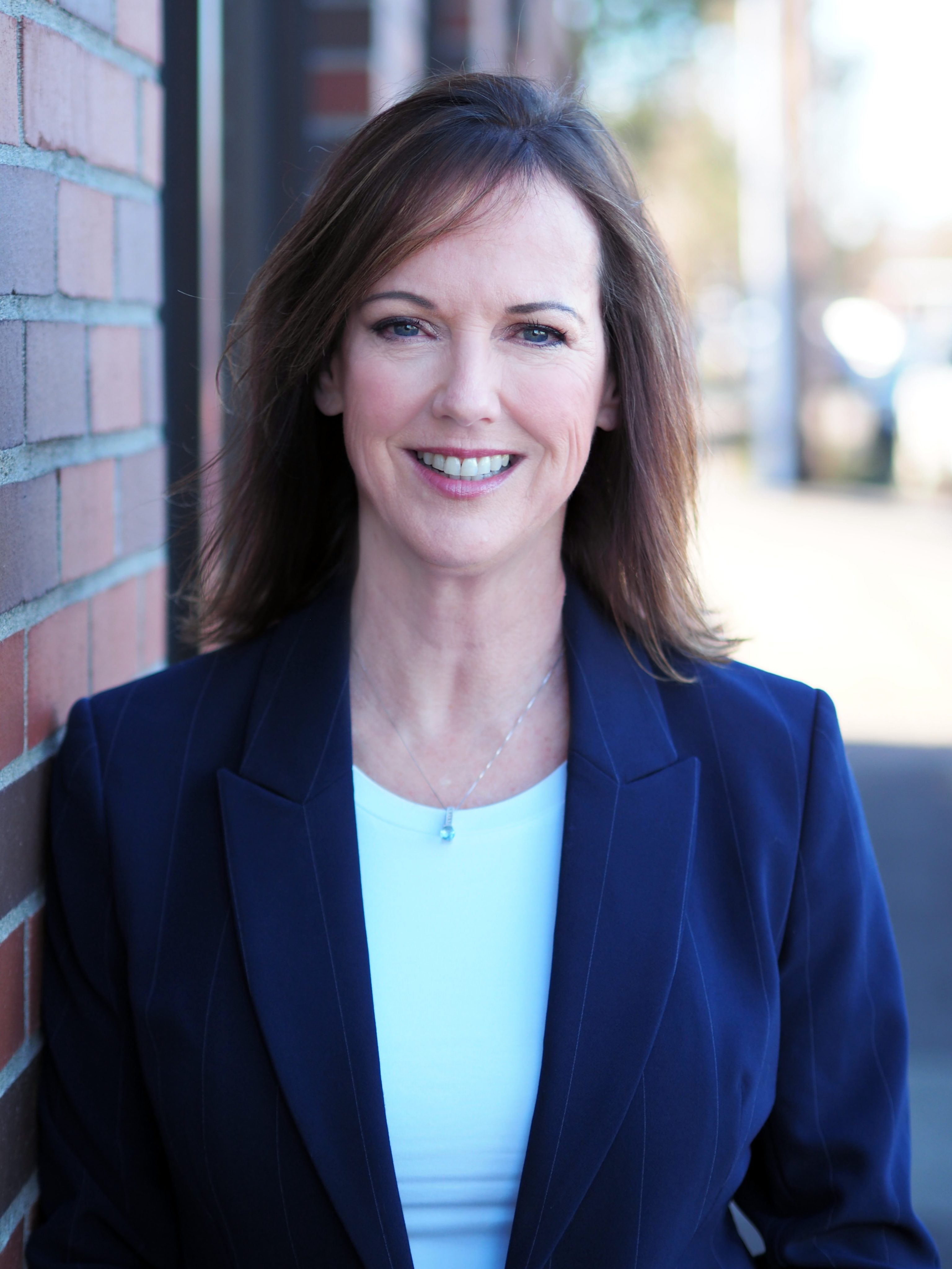 Sheri Johnson, a professional real estate agent with Oregon Life Property Group, smiling in a blue blazer.