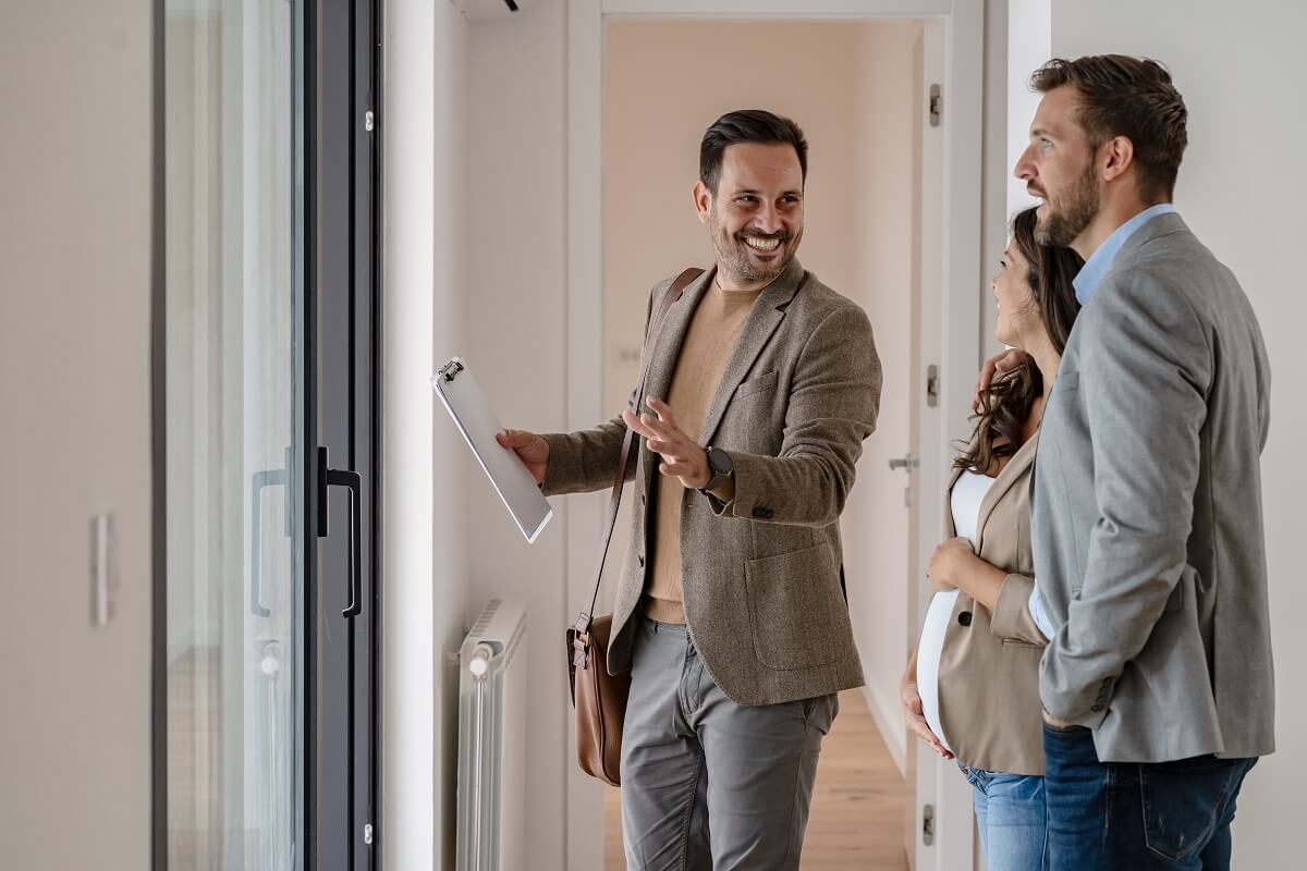 A young couple with a real-estate agent visiting an apartment