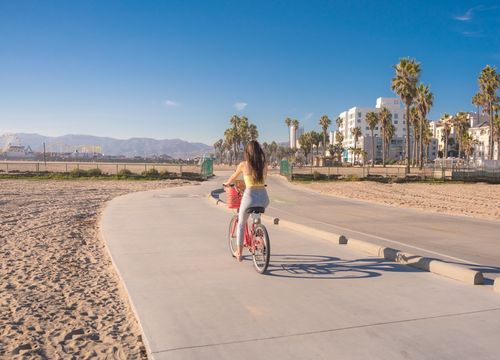 woman biking beach path