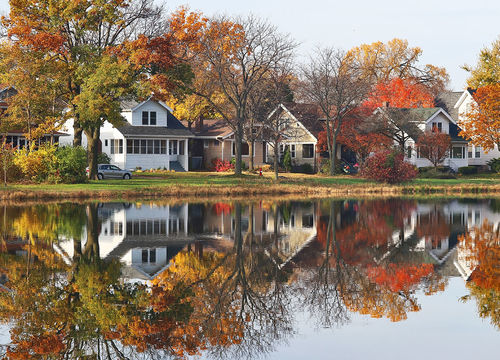 Fall-cityscape-with-private-houses-neighborhood-along-a-pond
