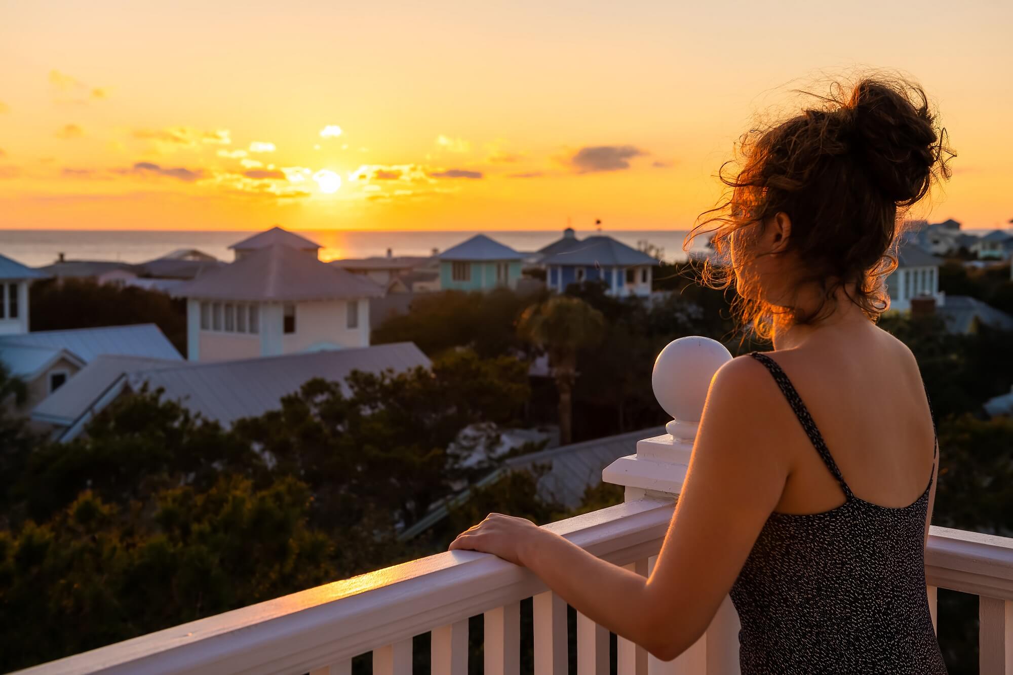 View on colorful sunset with young woman watching Gulf of Mexico