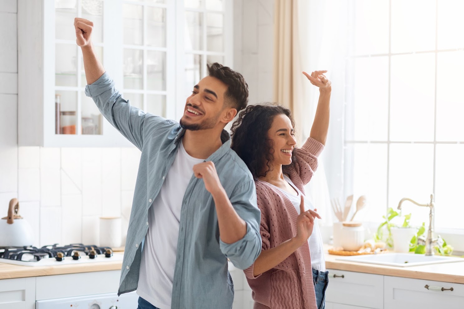 Domestic Fun. Cheerful Middle Eastern Spouses Dancing In Kitchen, Loving Arab Couple Fooling And Laughing At Home, Young Family Of Two Enjoying Spending Weekend Time Together, Copy Space