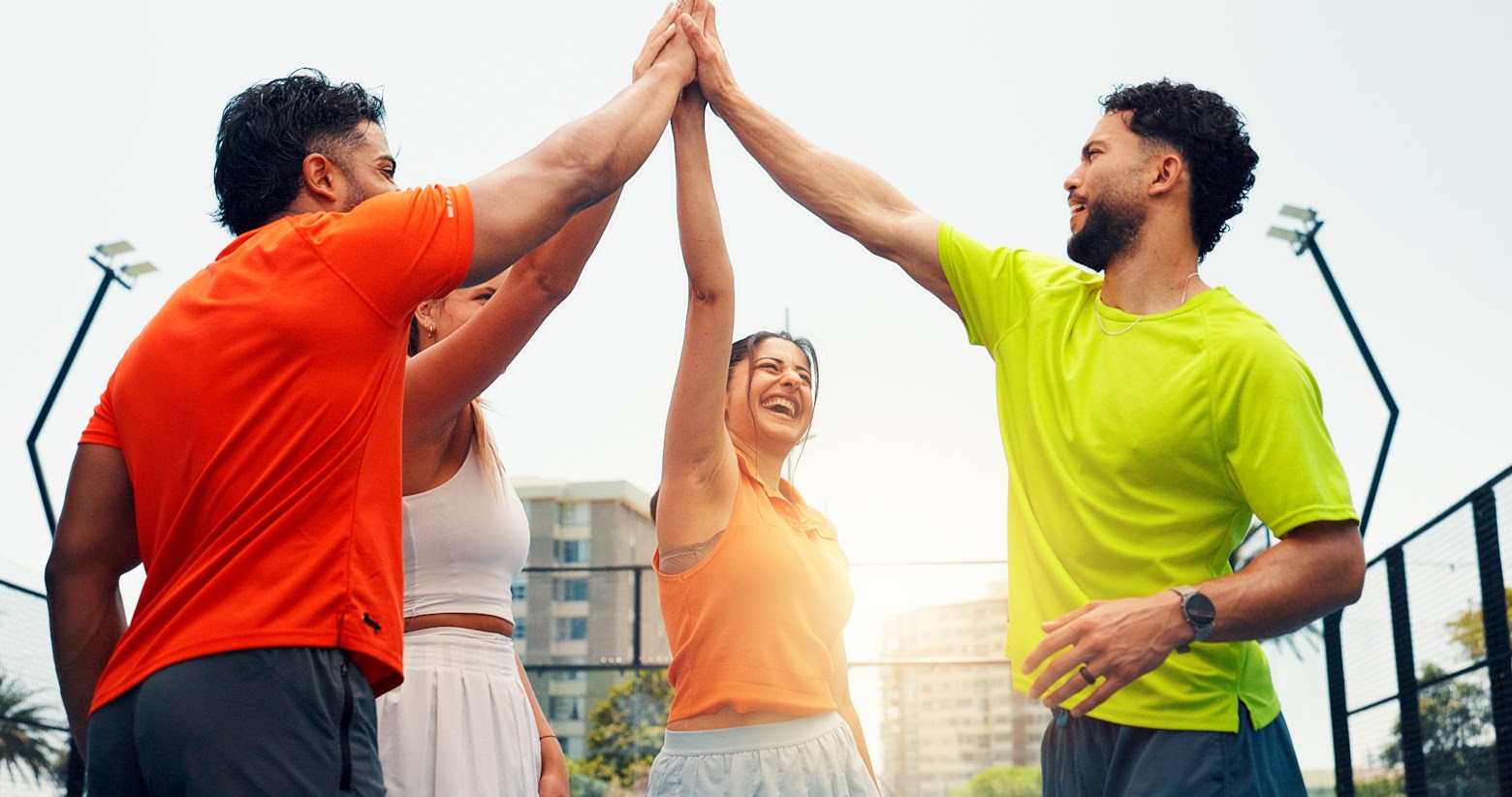 High five, fitness and group of people on court with solidarity, unity and partnership at padel match. Happy, flare and team of athletes with hands together for training, workout or game outdoor.