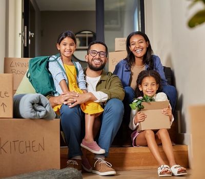 family sitting on stairs surrounded by moving boxes