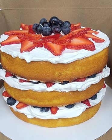 3 layer cake with strawberries and blueberries